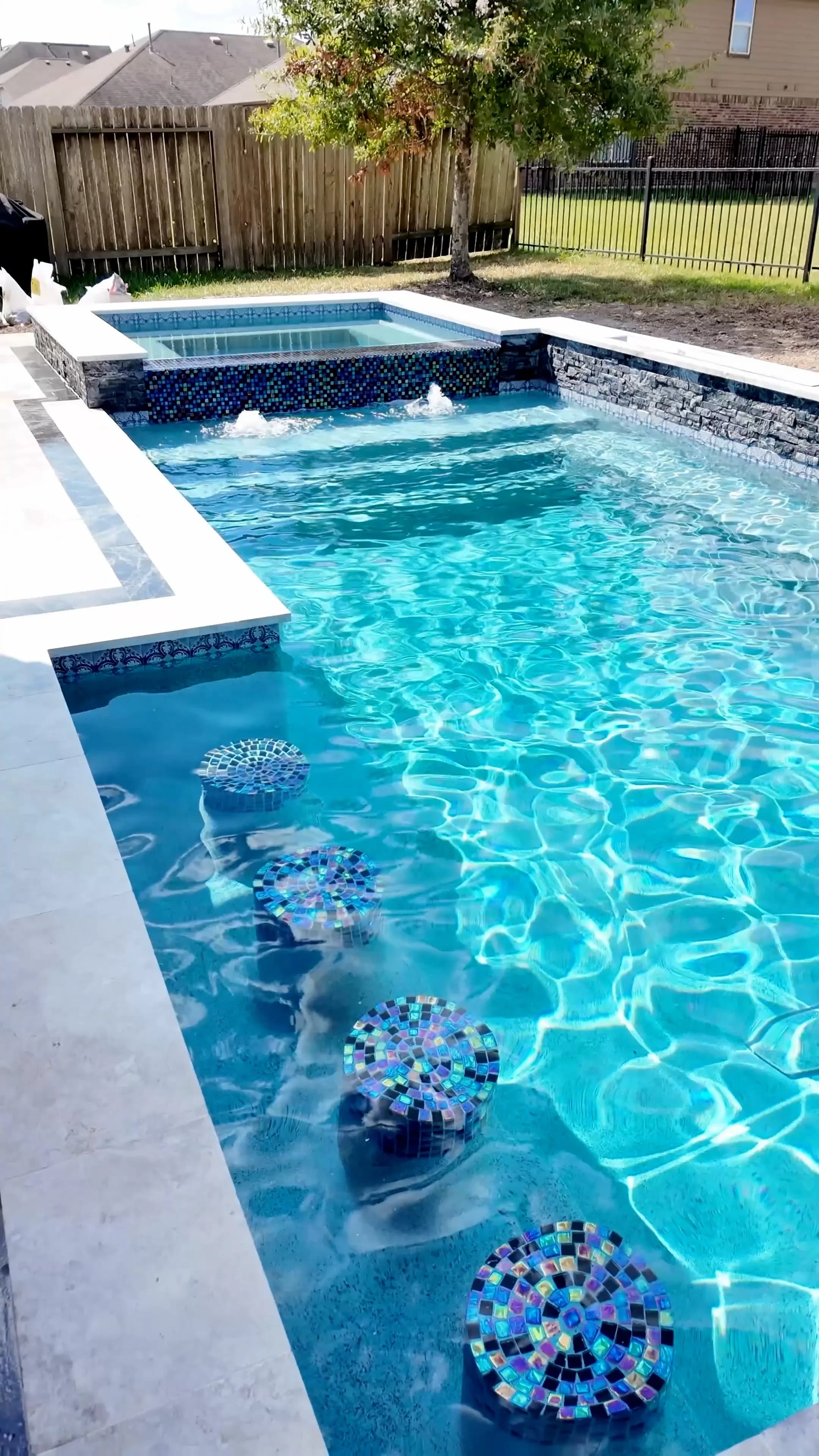 Looking down the pool to the glass-tile spa and bubbler fountains in Cypress